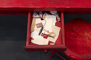 Alison Saar / 
Set to Simmer (detail), 2019 / 
wood, ceiling tin, enamel paint ceiling tin wire, found table, chair, and skillet with texts by Dionne Brand / 
Table and figure: 65 x 72 x 36 in. (165.1 x 182.9 x 91.4 cm) / 
Chair: 38 x 16 x 16 in. (96.5 x 40.6 x 40.6 cm)