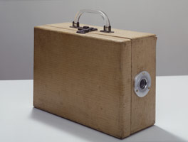 Michael C McMillen / 
Studio, 2004 / 
found vintage luggage, hand machined eyepiece, battery, lamp, button switch and miniature interior / 
9 3/4 x 13 1/2 x 5 1/4 in (24.8 x 34.3 x 13.3 cm)