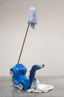 Olga Koumoundouros / 
Split Job, 2010 / 
push around buggy, worn T-shirt, 1 gallon milk container, mop, plaster, smooth-cast 300 plastic / 
overall: 82 x 27 x 39 in. (208.3 x 68.6 x 99.1 cm) 